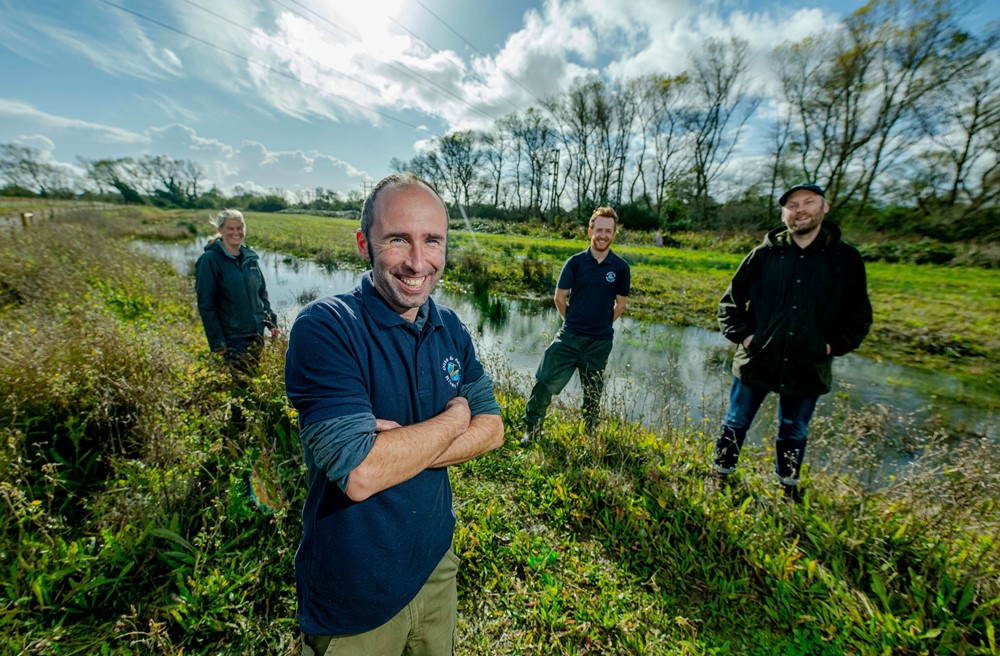 Group of men standing at the edge of a river bank