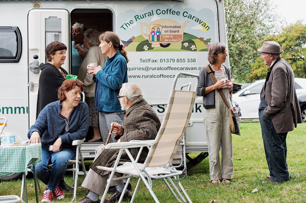 Mix of people siting and standing drinking coffee