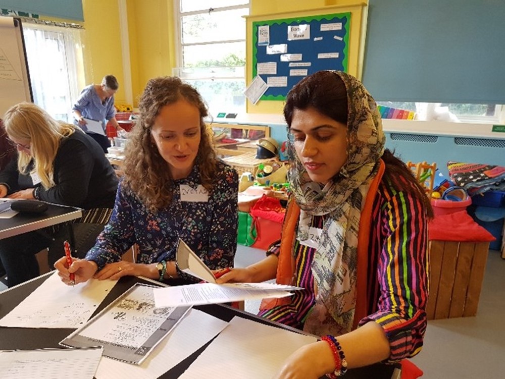 Two women sat talking and working