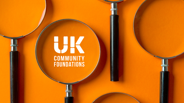 Magnifying glasses lined up on an orange background. In one glass lens is the UKCF logo in white.