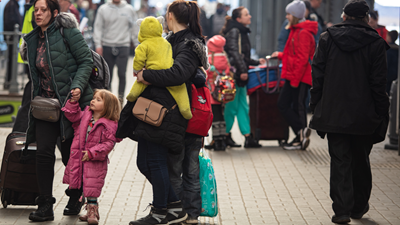 Ukrainian families gathered at Lviv Ukraine train station in March 2022, loaded with suitcases.