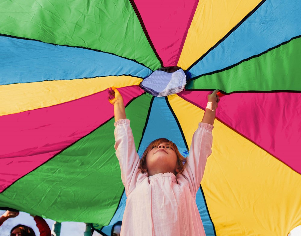 Little girl with arms up under bright coloured ballon canvas